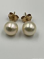 Front view of both pearl stud earrings on flat surface