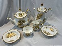 Frontal view of all six pieces arranged on grey backdrop