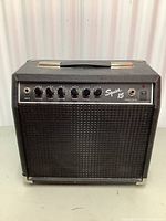 Front view of Fender Squier 15 amp showing control panel and speaker grille.