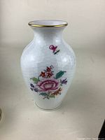 Front view showing pink floral hand painted design and gold rim on white textured porcelain vase standing 6 inches tall.