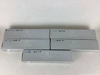 Five closed gray storage boxes labeled Thomas O’Brien Reed & Barton with handwritten notes for item quantities.