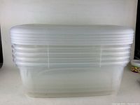 Front view of stacked clear plastic storage bins with lids showing the size and appearance