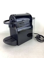 Right-side view of the black Nespresso coffee machine showing the water reservoir and power cord.