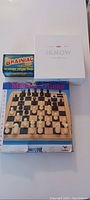 Photo of three boxed games: Master Chess set with visible wooden chess pieces, Brainiac quiz game, and I Know board game in white box.