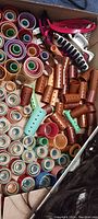 Close-up photo of plastic hair rollers in various sizes and rainbow colors, along with large pink and black hair clips and smaller turquoise and orange rollers.