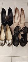 Photo showing four pairs of shoes: black high heels with bow, nude high heels, silver flats, and black strappy heels
