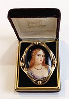 Photo of vintage cameo brooch in its original velvet box marked Bond Boyd Originals, showing the front face with hand-painted portrait and gold frame.