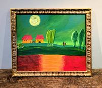 Full view of framed oil painting on table surface.