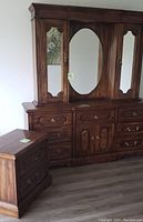 Two-piece wooden furniture set: dresser with mirror and bedside table, dark wood finish