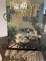 Front cover of 'Provence The Beautiful Cookbook' showing outdoor dining scene with wine and food, emphasizing its culinary and cookery theme.