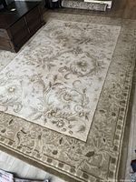 Overview of full rug laid on floor next to furniture