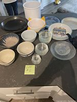 Overview of assorted bowls, crock, plates, teapot on a table showcasing size and variety