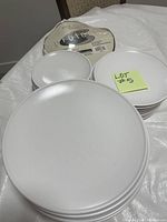 Stack of 10-inch white dinner plates, smooth with plain white porcelain surface.
