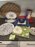 Photo showing the full assortment of platters, wine crock, small bowl and handmade basket arranged on a countertop.