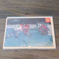 Front view of card showing hockey game action with player #9 making a save.