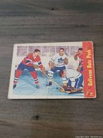 Front of 1955-56 Parkhurst Jean Beliveau Bats Puck hockey card number 74 showing players on ice including Beliveau in Canadiens uniform.