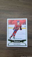 Front of Cole Caufield rookie hockey card from Parkhurst showing player in Montreal Canadiens uniform skating on ice.