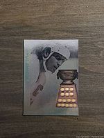 Front of the hologram card showing Wayne Gretzky in hockey gear and the Art Ross Trophy in holographic form.
