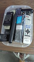 Top view of the box showing multiple remotes including Panasonic, AMGA, Bose and Sony brands.