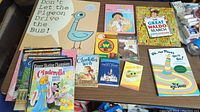 Photo showing the majority of the children's books arranged on a table, including Don't Let the Pigeon Drive the Bus!, Charlotte's Web, and Oh, the Places You'll Go!