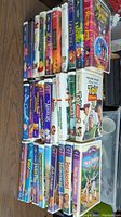 Photo showing entire lot of 20 Disney VHS tapes stacked on each other, titles visible include Toy Story 2, Aladdin, The Lion King, and more.