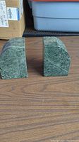 Side-by-side view of two green marble bookends showcasing different shapes and natural veining.