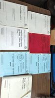 Seven naval training and military manuals arranged on a table including Naval Orientation, Military Requirements for Petty Officer Third Class, and several communications manuals in blue covers.
