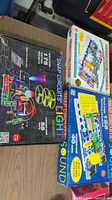 Three Snap Circuits kits boxes stacked including Light and Sound editions