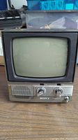 Front view of a small vintage Sony TV with CRT screen showing the entire front, controls and speaker grille.