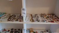 Wide view of necklaces laid out on two shelves, showcasing multiple chains, bead necklaces and some earrings