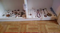 Shelf display of assorted jewelry including necklaces, brooches and scarf ring