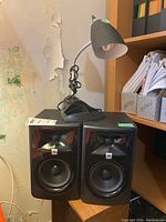 Both speakers side by side with lamp on left speaker
