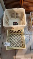 Stack of five beige Rubbermaid square laundry baskets with ventilation grid design.