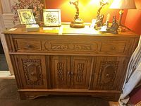 Front view of carved oak sideboard with top drawer and two doors