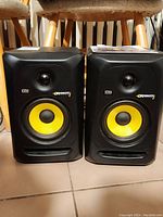 Front view of both KRK Rokit 5 speakers showing yellow woofers