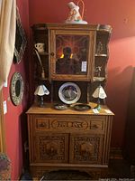 Front view of entire cabinet showing upper glassed cupboard, side shelves, center drawer and lower doors