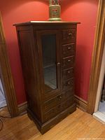Full view of cabinet showing overall shape, glass door, and drawer arrangement