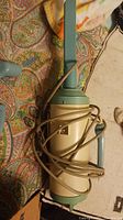 Vintage Troy portable vacuum showing the main canister body and wrapped cord.