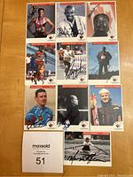 Photo showing 10 autographed athlete cards arranged on a table with a lot number card.