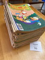 Stack of vintage comic books about 6 inches thick placed on a wooden surface