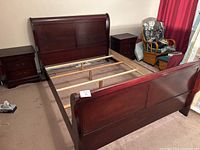 Full view of queen sleigh bed frame with headboard, footboard, and two matching nightstands