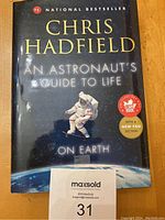 Front cover of Chris Hadfield's book 'An Astronaut's Guide to Life on Earth' showing a space-themed design and author name.