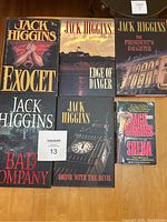 All six Jack Higgins books arranged together on floor, five hardcovers and one softcover, showing front covers with titles and author name clearly visible.