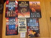 Six Jack Higgins books displayed on a wooden surface, showing front cover artwork and titles.