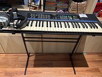 Front view of Kawai FS660 keyboard on black metal stand with headphones on left side of keyboard.