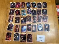 Full view of 32 Kiss cards laid on a table showing individual and group shots with visible tape residue