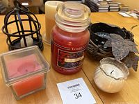 Photo showing Yankee Candle Barry Bramble candle with other candles and metal candle holders on table.