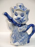 Front view of ceramic bear-shaped teapot showing bamboo spout and hat detail.