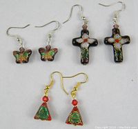 Three pairs of cloisonné earrings displayed together showing different shapes and colors