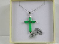 Front view of jadeite cross pendant on sterling silver chain with attached tags.